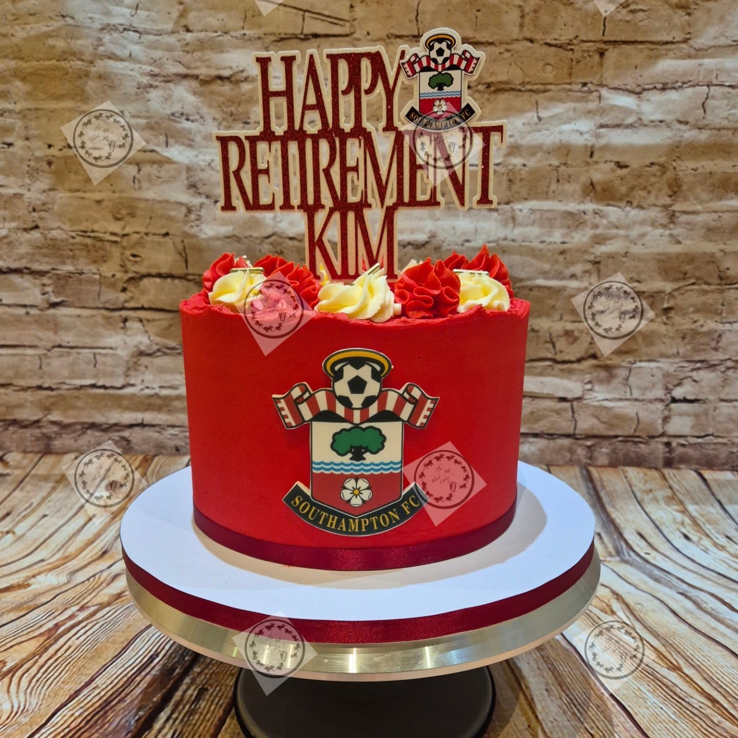 Red buttercream celebration cake decorated with a Southampton FC crest for a retirement celebration